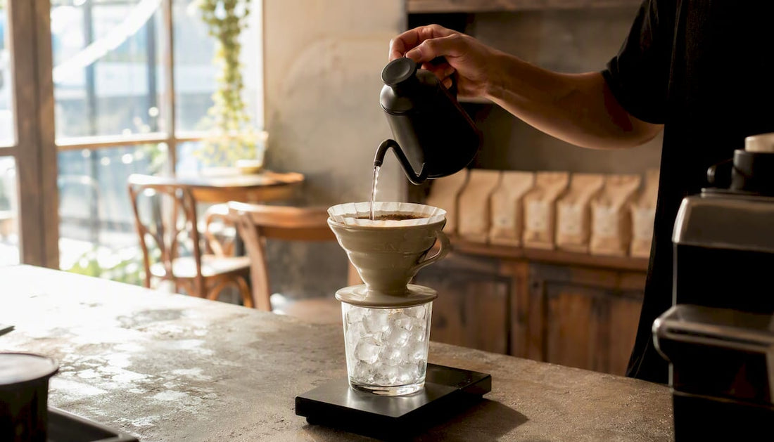 Pour-over brewing coffee over ice cubes close-up
