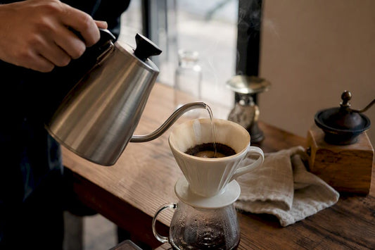 Hands pouring coffee with gooseneck kettle